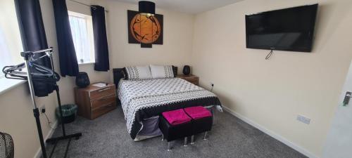 a bedroom with a bed and a flat screen tv at The Hive Great Yarmouth in Great Yarmouth