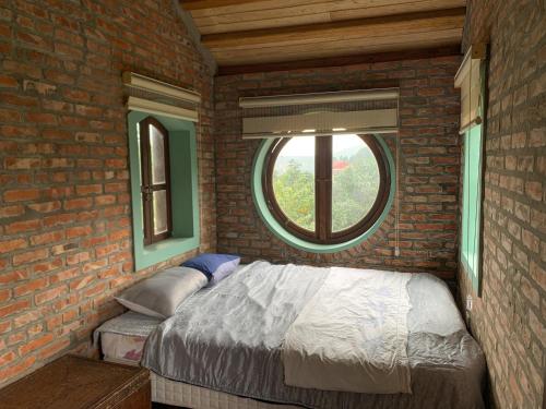 a brick bedroom with a bed and a window at Zen Villa - Retreat Homestay in Bắc Ninh