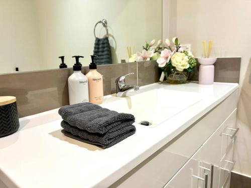 a bathroom counter with a sink with a towel at Guest house in Harrington Park in Narellan