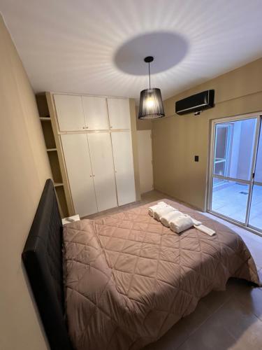 een slaapkamer met een bed en een groot raam bij Apartamento Céntrico para 4 personas con Patio in Santiago del Estero