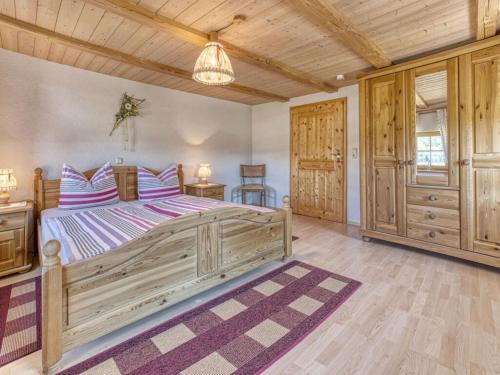 a bedroom with a large bed and wooden ceilings at Holiday home Sterl in Eppenschlag