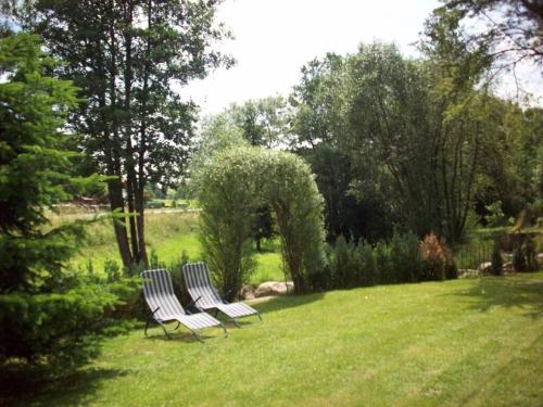 three chairs sitting in the grass in a field at Holiday home Sterl in Eppenschlag in Eppenschlag