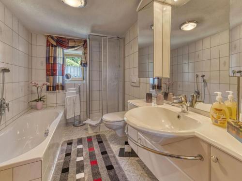 a bathroom with a tub and a sink and a toilet at Holiday home Sterl in Eppenschlag