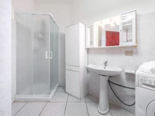 een witte badkamer met een wastafel en een douche bij Elegant apartment with terrace at Cala Liberotto in Cala Liberotto