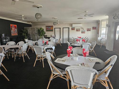 a dining room with white tables and white chairs at Cameo Inn Motel in West Wyalong