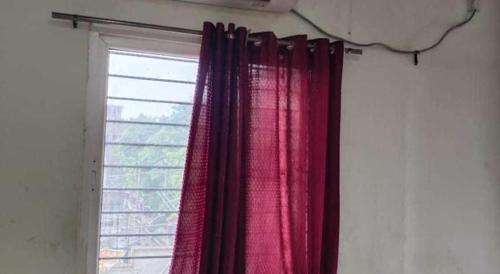 una finestra con tende rosa in una stanza di hotel kings a Gulbarga