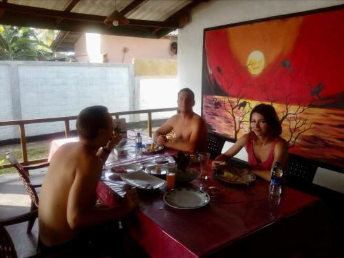 a group of people sitting around a table in a restaurant at River Paradise in Kalutara