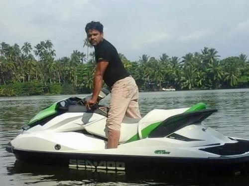 a man standing on a jet ski in the water at River Paradise in Kalutara
