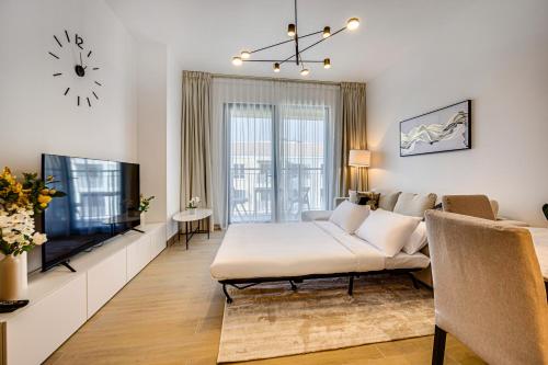 a living room with a couch and a tv at Splendid brand new 1BD apartment near the beach in Dubai