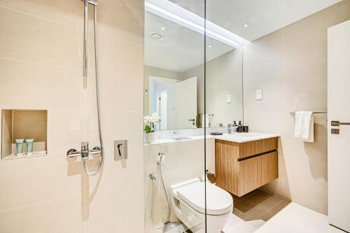 a bathroom with a shower and a toilet and a sink at Splendid brand new 1BD apartment near the beach in Dubai