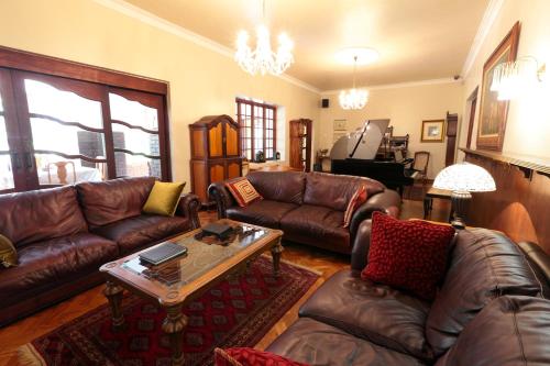 a living room with leather couches and a coffee table at Kleinkaap Boutique Hotel in Centurion