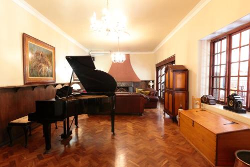 a living room with a piano and a couch at Kleinkaap Boutique Hotel in Centurion
