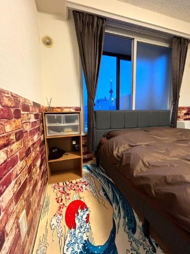 a bedroom with a bed and a brick wall at E-Horizon北2条 in Sapporo