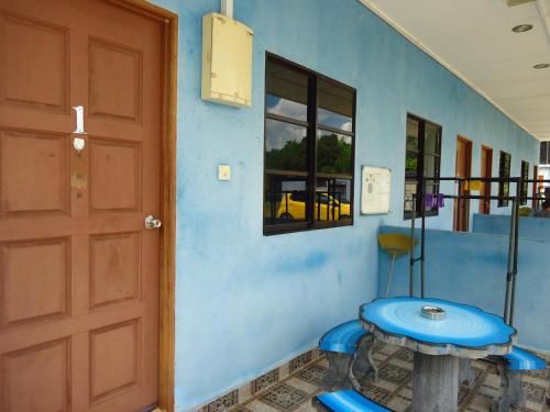 Habitación azul con puerta azul y mesa en D'pinggir Guest Room, en Kuala Tahan