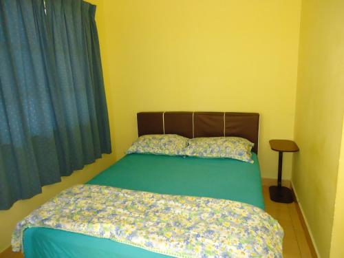una camera da letto con un letto con un piumone verde e una finestra di D'pinggir Guest Room a Kuala Tahan