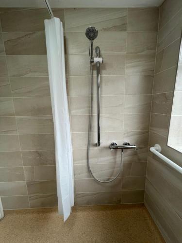 a shower in a bathroom with a shower head at Luxury Super King Bed - Private Flower Garden in Stratford-upon-Avon
