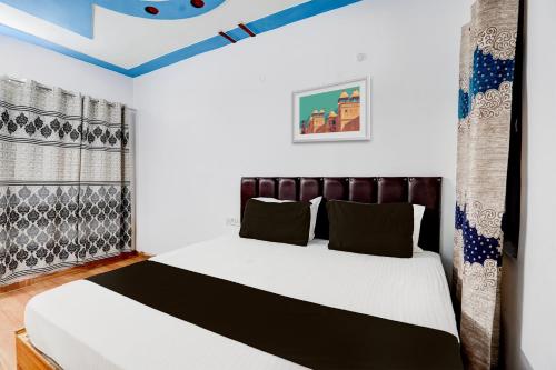una camera da letto con un letto con un piumone bianco e nero di OYO Premier Jim Corbett Home Stay a Ramnagar