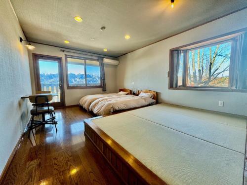 1 dormitorio con 2 camas y ventana en Place yatsugatake Lodge&cottage, en Hokuto
