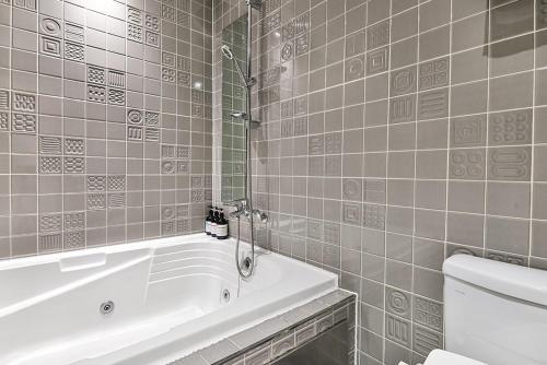 a bathroom with a bath tub and a toilet at Brown Dot Hotel Incheon Jakjeon in Incheon