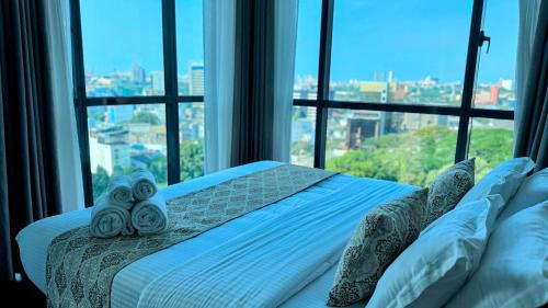 a bed in a room with a large window at Cosy home in heart of Colombo at Capitol Twinpeaks. in Colombo
