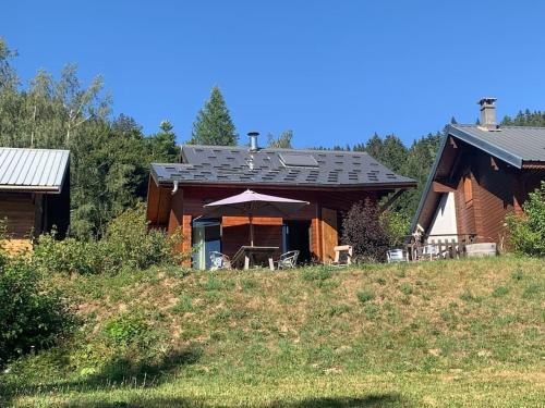 a log cabin with a table and chairs in front of it at Beautiful *** Chalet Le Gentiane in L'Alpe du Grand Serre in La Morte