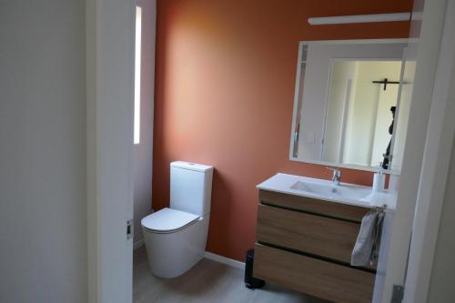 uma casa de banho com um WC, um lavatório e um espelho. em The Tree house em Paraparaumu