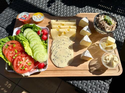 een houten dienblad met kaas en andere etenswaren op een tafel bij Apartament Sweet Time in Huta Szklana