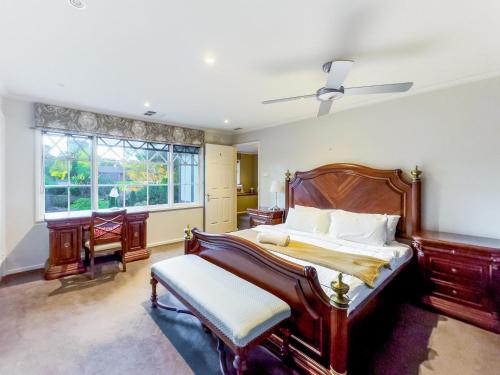 Park Orchards的住宿－Pride Leisure Tudor House，一间卧室设有一张大床和一个窗户。