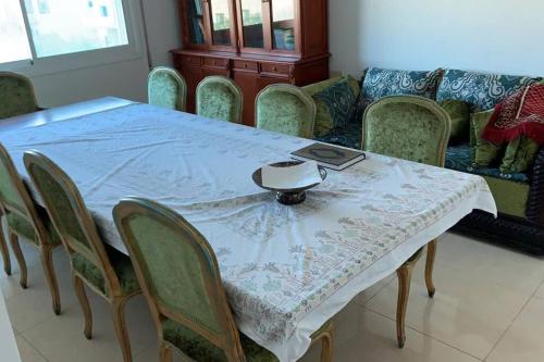 uma mesa de jantar com cadeiras e uma toalha de mesa branca em Convenient Spacious apartment em Amã