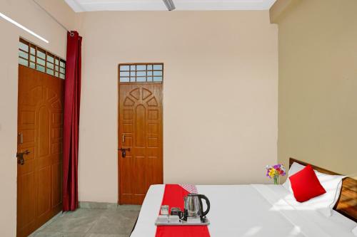 a bedroom with a bed with red pillows and a door at Flagship Sweet Homes in Ghaziabad