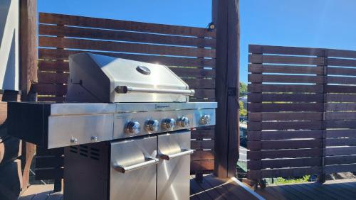 a grill sitting on a deck next to a fence at Place yatsugatake Lodge&cottage in Hokuto