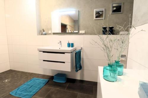 een badkamer met een wastafel en een spiegel bij ROBERTA - mit Terrasse und Sauna in Diemelsee