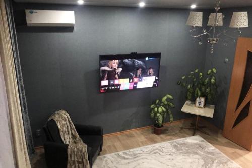 sala de estar con TV de pantalla plana en la pared en Дизайнерская квартира с барной стойкой по Бозтаева, en Semey