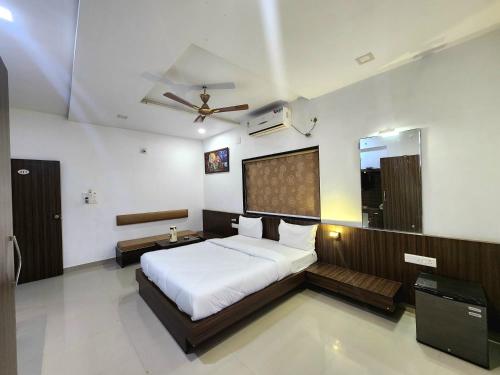 1 dormitorio con 1 cama y ventilador de techo en Hotel Amidhara, en Dwarka