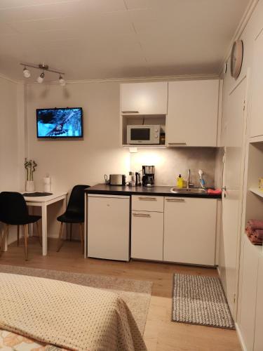 una cocina con armarios blancos y una mesa con sillas. en Kauppakatu 57 - 8, en Varkaus