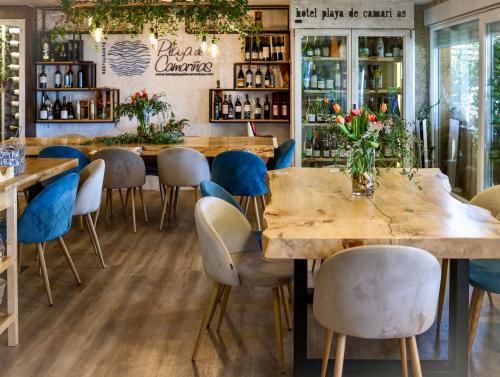 een restaurant met houten tafels en blauwe stoelen bij Playa de Camariñas in Camariñas