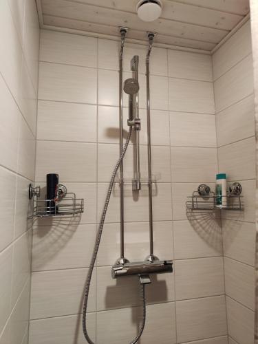 a shower with a shower head in a bathroom at Kauppakatu 57 - 8 in Varkaus