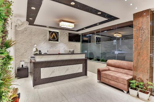 a lobby with a reception desk and a brown couch at The Auberge Boutique Hotel - Manyata Tech Park in Bengaluru