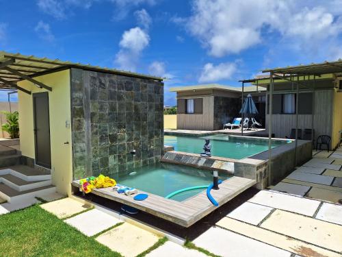 a backyard swimming pool with a house and a swimming pool at Villa Zen in Flic-en-Flac