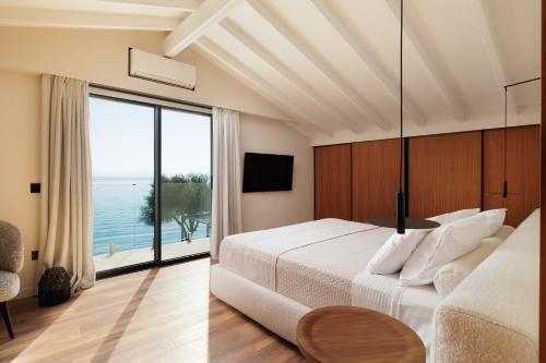 a bedroom with a large bed and a large window at Nisos Villa Emerald in Kornáta