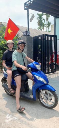 a woman and a child sitting on a scooter at The Dragon Villa Hoi An in Hoi An