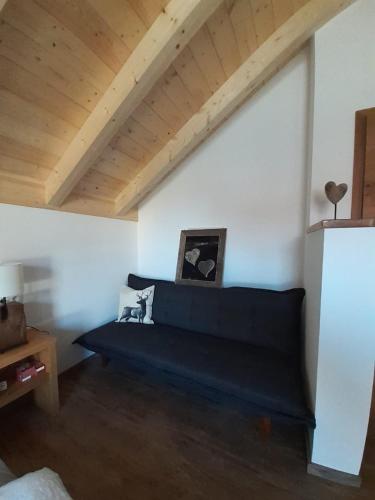 a living room with a blue couch in a attic at Alpenchalet Allgäu in Oy-Mittelberg