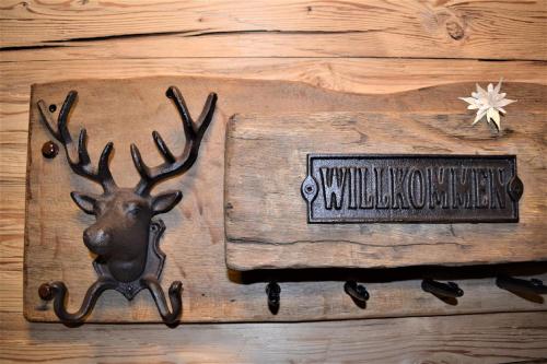 a sign on a wall with a deer head on it at Alpenchalet Allgäu in Oy-Mittelberg