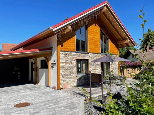a house with an umbrella in front of it at Alpenchalet Allgäu in Oy-Mittelberg