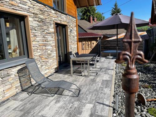 a patio with a table and chairs and an umbrella at Alpenchalet Allgäu in Oy-Mittelberg