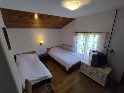 Habitación pequeña con 2 camas y TV. en Вила Беевски, en Gela
