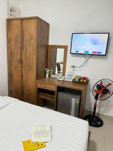 a bedroom with a bed and a desk with a computer at Mat Troi Vang Dalat Hotel in Da Lat