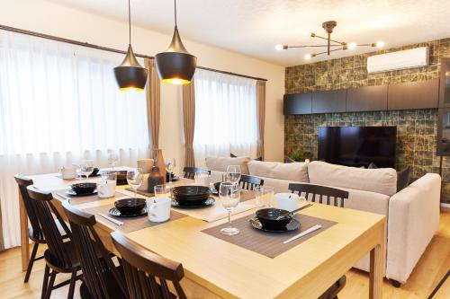 a dining room with a large wooden table and chairs at It'ta de LYCKA in Osaka