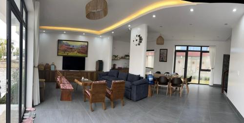 uma sala de estar com um sofá azul e uma mesa em Bình Yên Villa - Mộc Châu em Mộc Châu