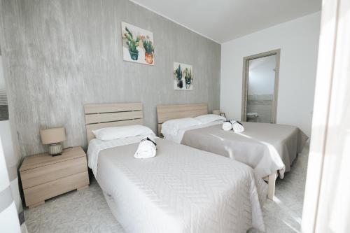 a bedroom with two beds and a mirror at Gioema in Borgo Vodice